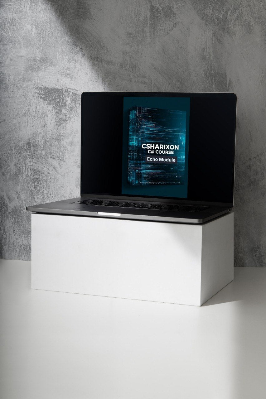 A black laptop sits open on a white display block against a textured gray wall. The screen is on and displays a dark blue book cover with the text 'CSHARIXON CE Course' and 'Echo Module'.